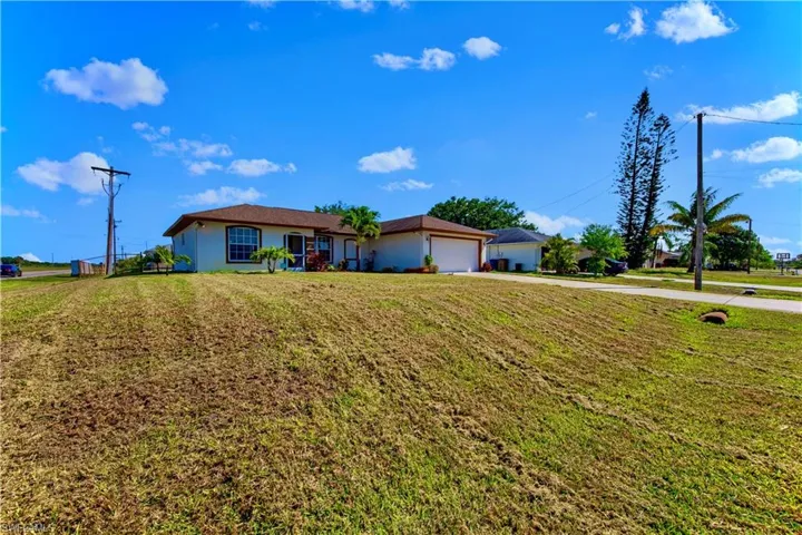 Single story home with a front lawn, concrete driveway, a garage, and stucco siding