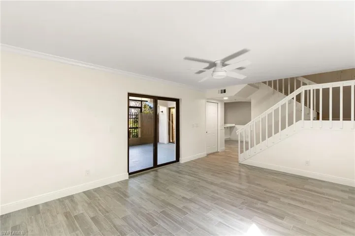 Spare room with ceiling fan, wood tiled floors, and crown molding