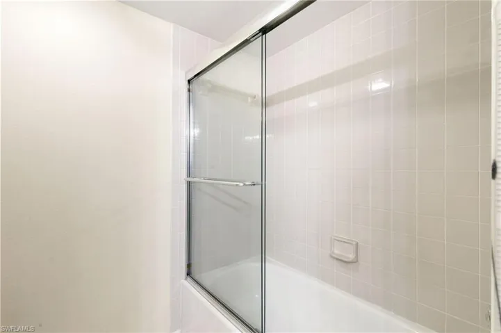 Bathroom featuring bath / shower combo with glass door