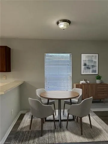 Dining space with dark wood-type flooring and baseboards