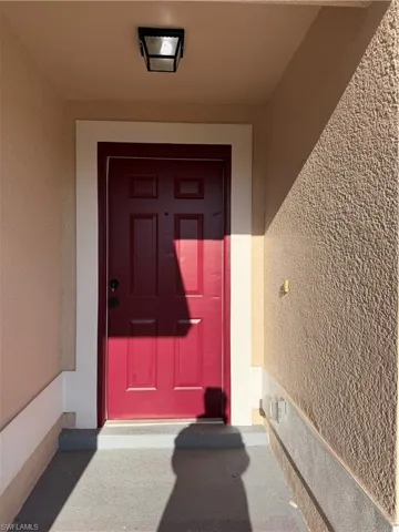 Property entrance featuring stucco siding and a porch