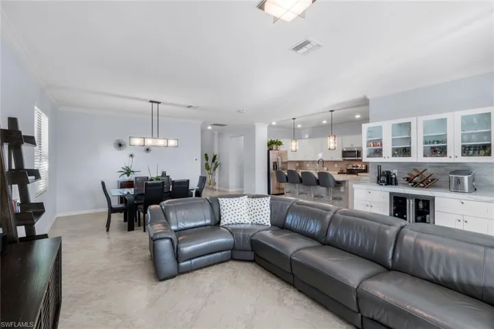 Living area featuring ornamental molding and wine cooler