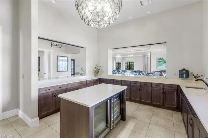 Full bathroom featuring light tile patterned floors, wine cooler, recessed lighting, vanity, and a chandelier