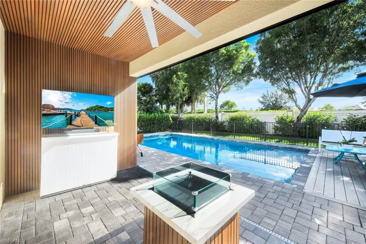 View of pool with a patio, a fire pit, a fenced backyard, and ceiling fan