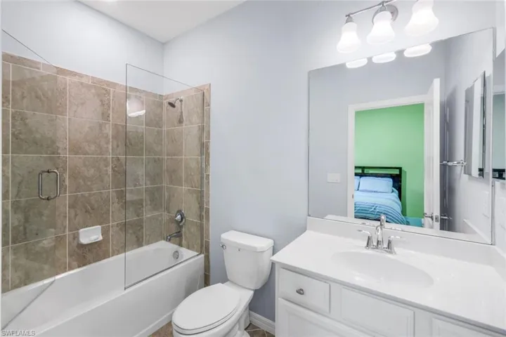 Ensuite bathroom featuring enclosed tub / shower combo and vanity