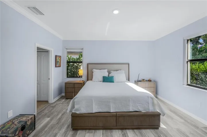 Bedroom featuring wood finished floors, ornamental molding, and recessed lighting