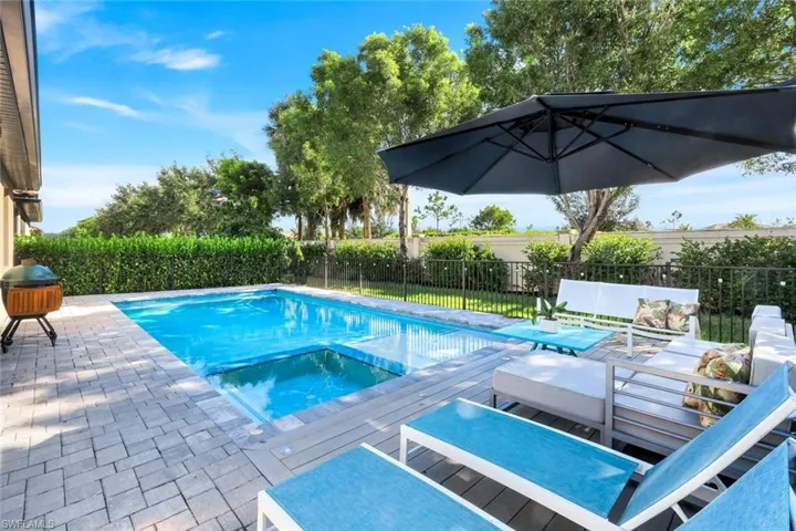 View of swimming pool featuring a pool with connected hot tub, a fenced backyard, and a patio area