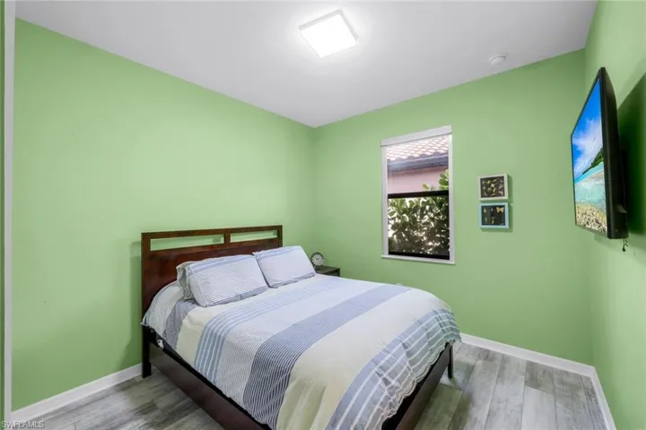Bedroom with wood finished floors and baseboards