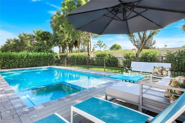 View of pool with a fenced backyard, a pool with connected hot tub, and a deck