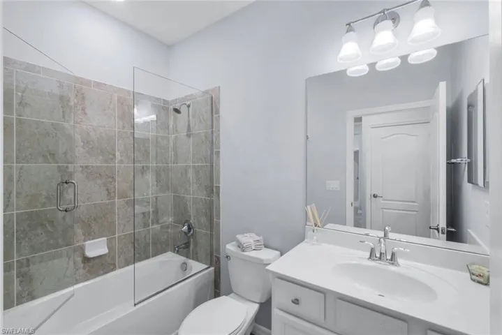 Full bathroom featuring bath / shower combo with glass door and vanity