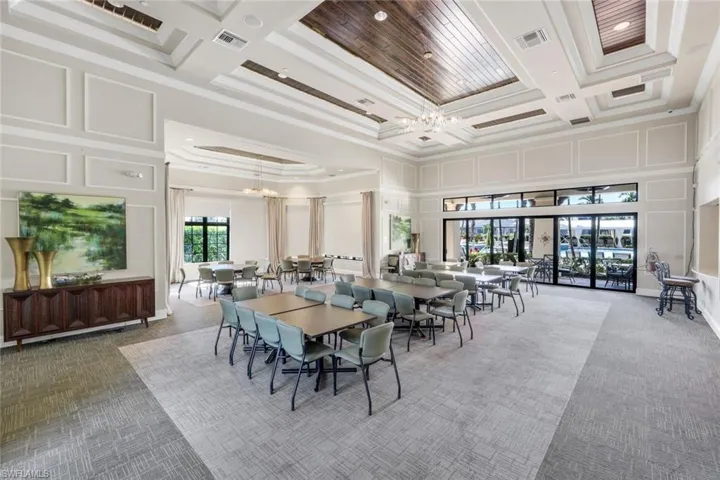 Dining area featuring light carpet, coffered ceiling, crown molding, beam ceiling, and a chandelier