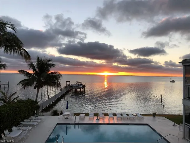 Community pool with a water view and a dock