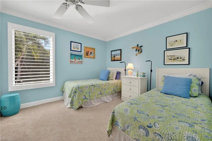Carpeted bedroom featuring crown molding and a ceiling fan