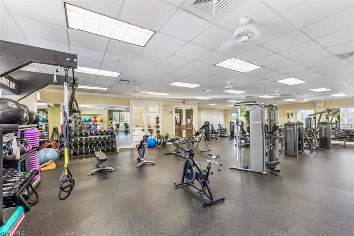 The property features a well-equipped fitness center with various exercise machines, free weights, and dedicated training areas