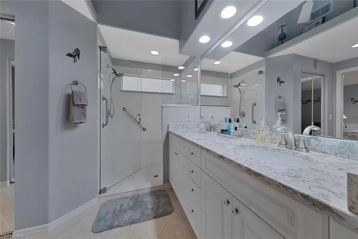 Bathroom featuring tile patterned floors, an enclosed shower, and vanity