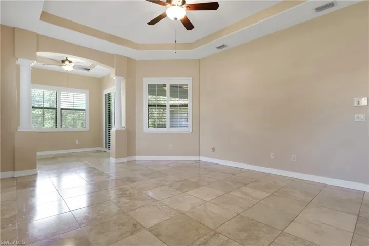 Empty room with a ceiling fan and a raised ceiling