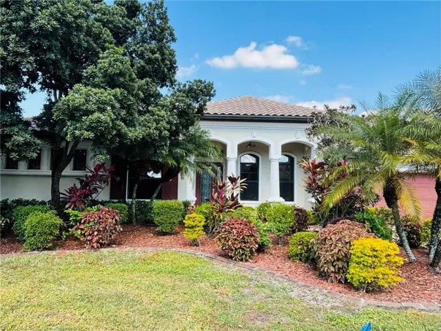 Mediterranean / spanish house with a tiled roof, stucco siding, a front yard, and a porch