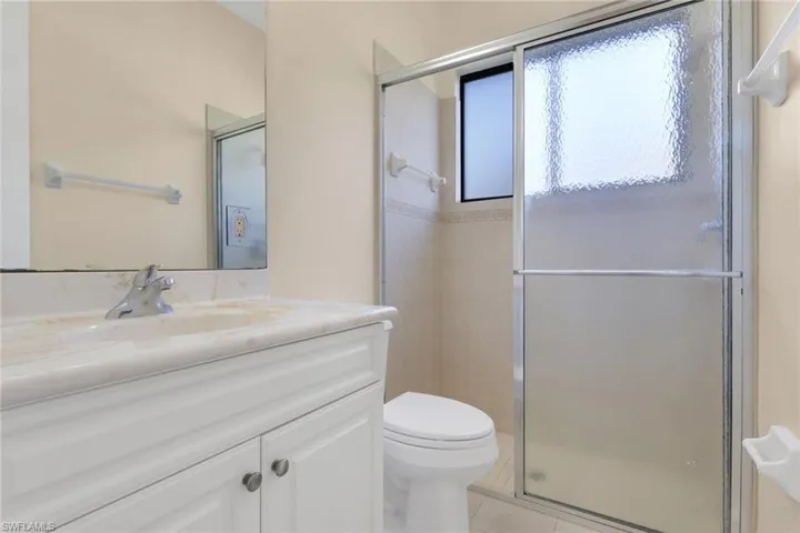 Full bath featuring vanity, a stall shower, and light tile patterned flooring