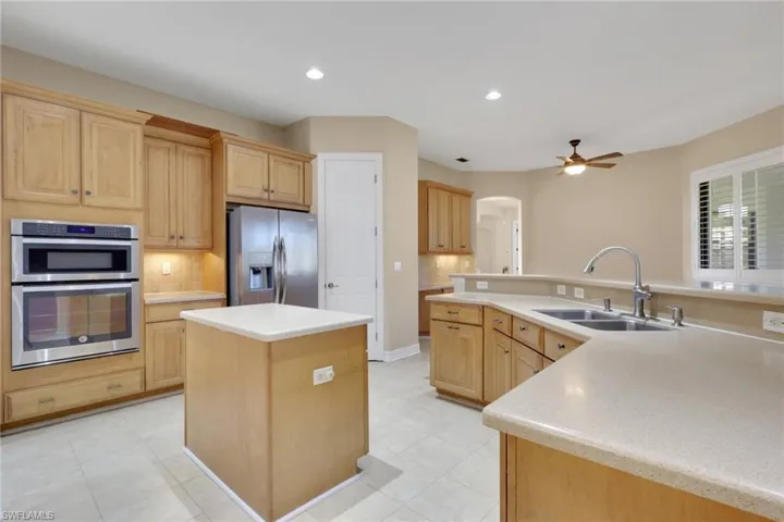 Kitchen featuring a center island with sink, stainless steel appliances, light brown cabinets, and recessed lighting