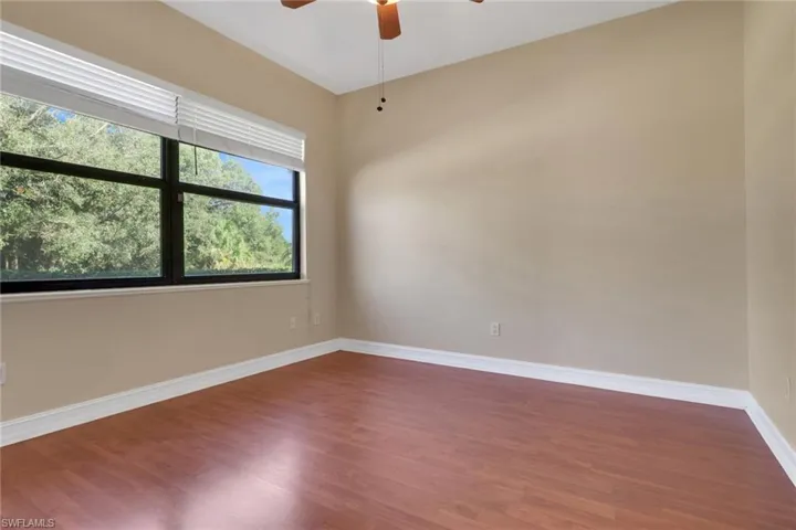 Spare room with wood finished floors and a ceiling fan