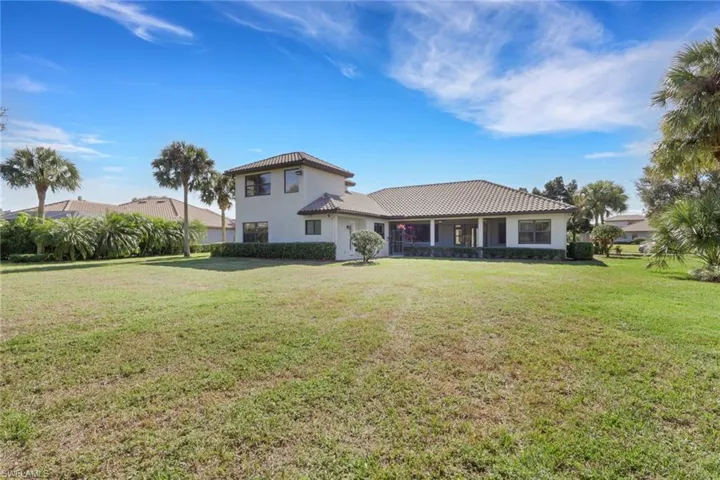 View of front facade featuring a front lawn, stucco siding, and a tile roof