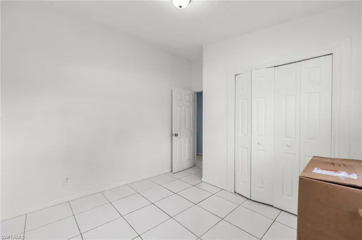 Unfurnished bedroom with light tile patterned floors and a closet