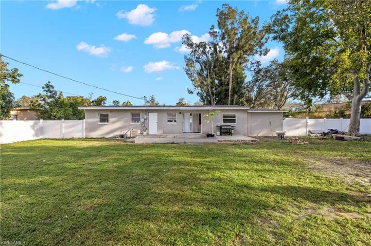 Rear view of property featuring a patio area and a lawn