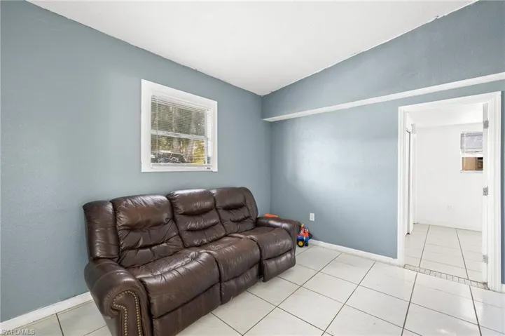 Tiled living room featuring vaulted ceiling