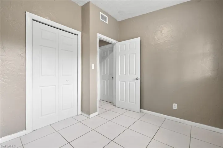 Unfurnished bedroom featuring a closet and light tile patterned flooring