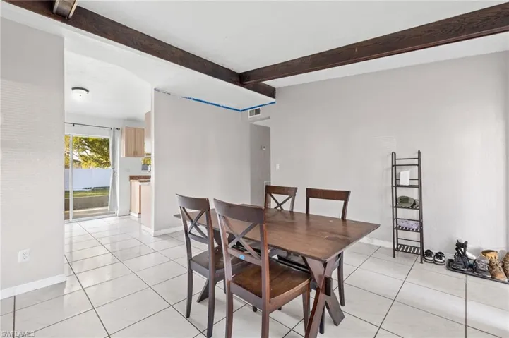 Tiled dining room with beam ceiling