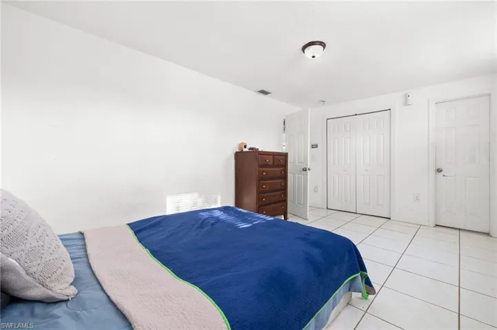 Tiled bedroom featuring a closet