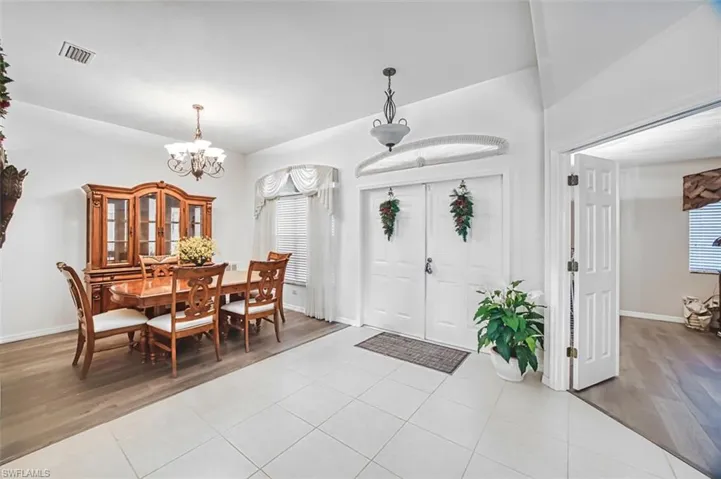 Entrance foyer with light wood-style flooring and a chandelier