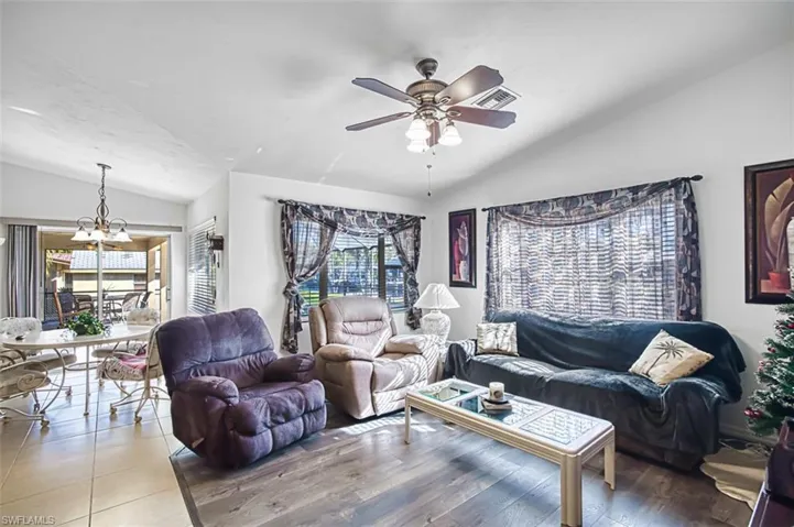 Living area featuring lofted ceiling, ceiling fan, and a chandelier