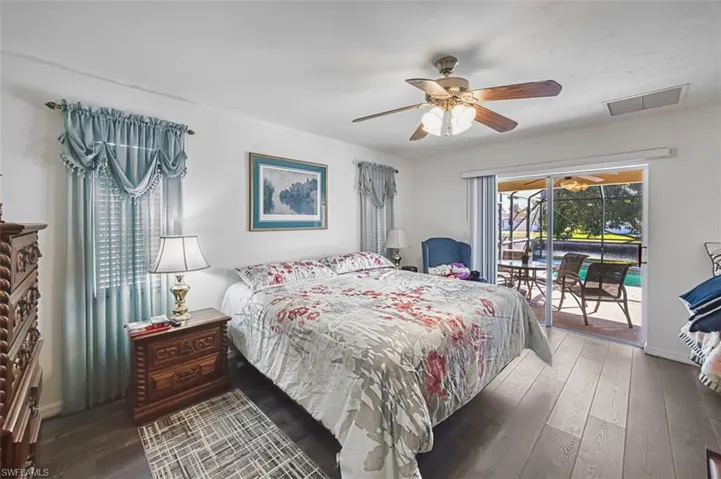 Bedroom featuring dark wood finished floors, access to exterior, and a ceiling fan