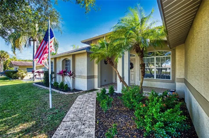 Property entrance with stucco siding and a lawn