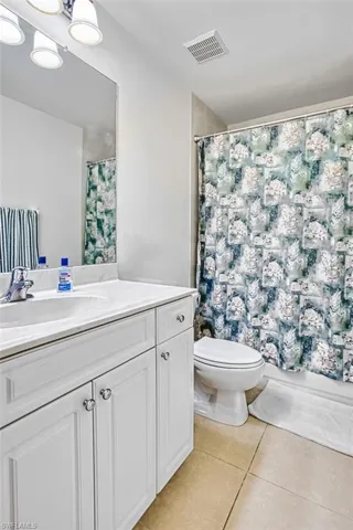 Full bath featuring vanity and light tile patterned floors