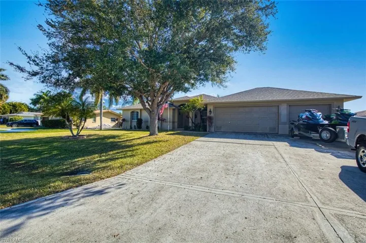 Ranch-style home with driveway, a front yard, and a garage