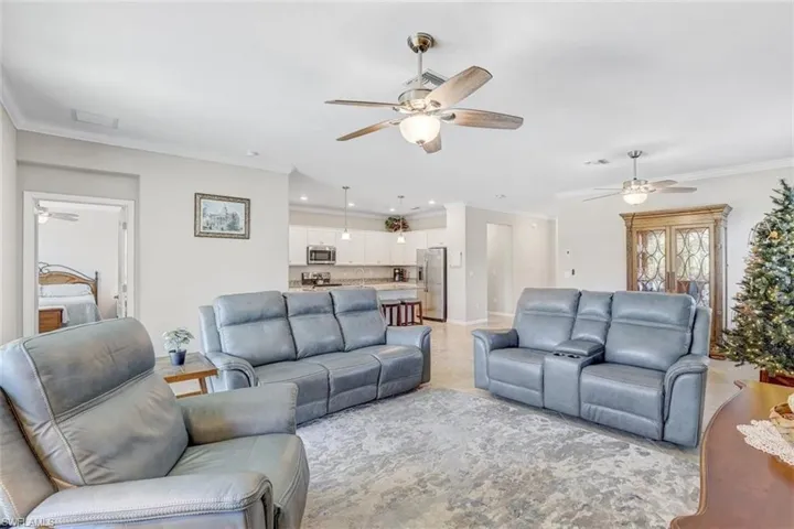 Living area with a ceiling fan, ornamental molding, and recessed lighting