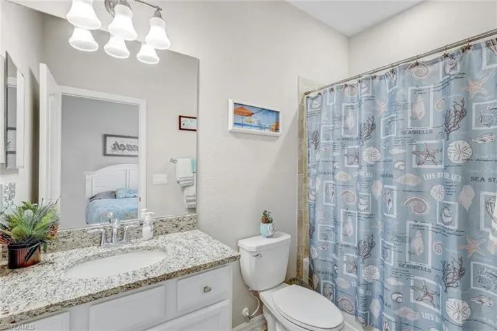 Ensuite bathroom featuring vanity, a shower with shower curtain, and a chandelier
