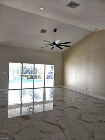 Spare room featuring ceiling fan and vaulted ceiling