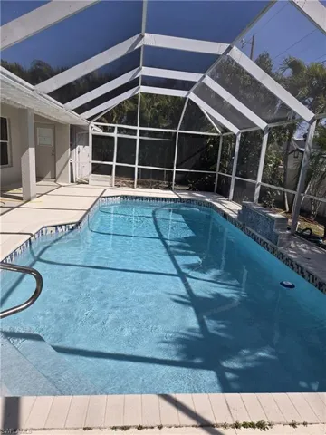 Outdoor pool featuring a sunroom, a lanai, and a patio