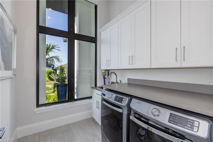 Laundry room with Maytag washer and dryer;Large sink and custom cabinets;plenty of natural lighting!
