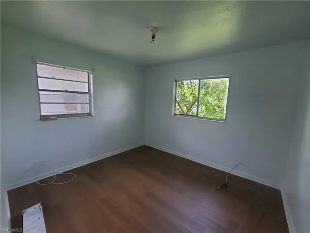 Spare room with dark wood-style flooring