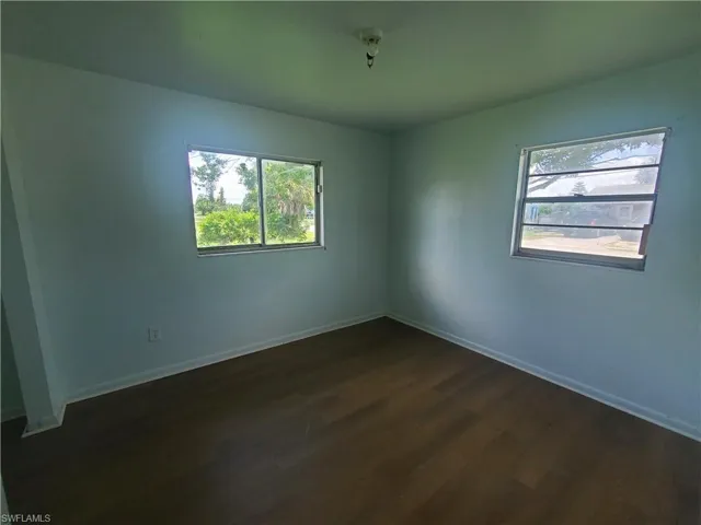 Spare room with dark wood-style flooring