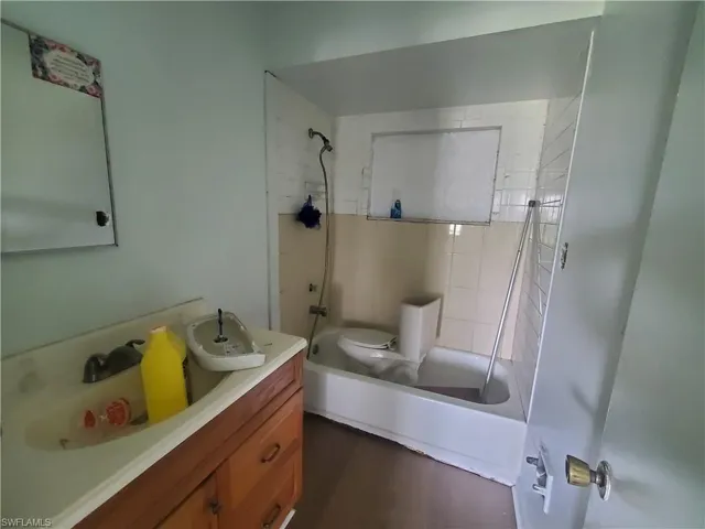 Full bathroom featuring vanity, tiled shower / bath combo, and toilet