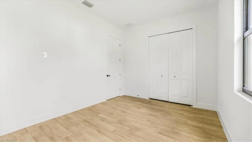 Unfurnished bedroom with light wood-style flooring and a closet