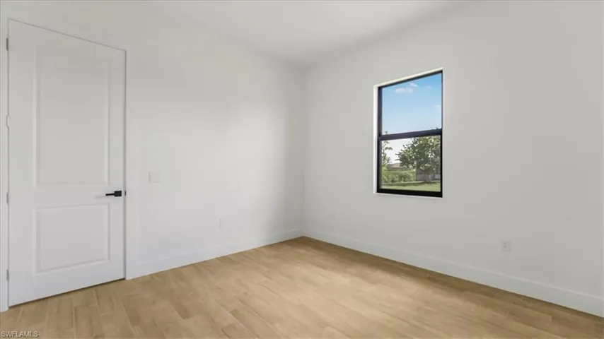 Spare room with light wood-style flooring and baseboards