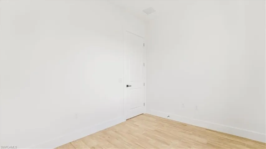 Empty room featuring baseboards and light wood-style floors