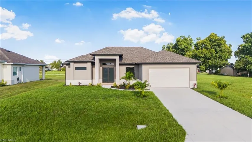 Prairie-style home with stucco siding, a front yard, driveway, an attached garage, and a shingled roof