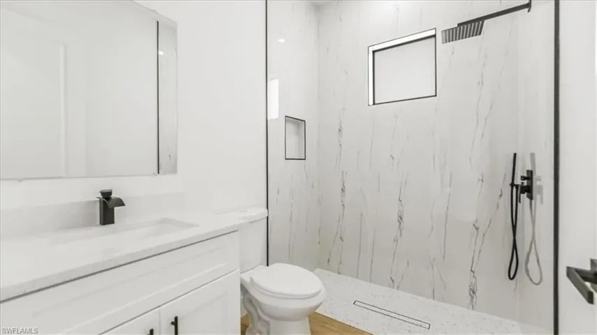Full bathroom with vanity and a marble finish shower